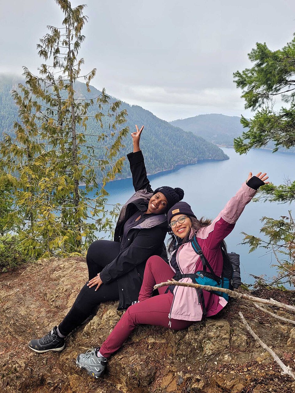 Maya and Elena smiling together on a scenic mountain hike